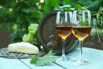 Wine with cheese on table in vineyard