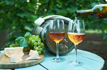 Pouring wine in glass in vineyard