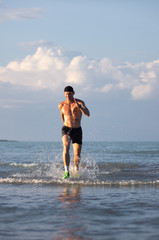 Sportsman running on the sea shore