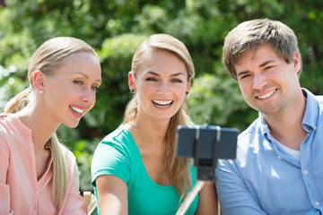 Obraz premium Happy Friends Taking Selfie With Selfie Stick