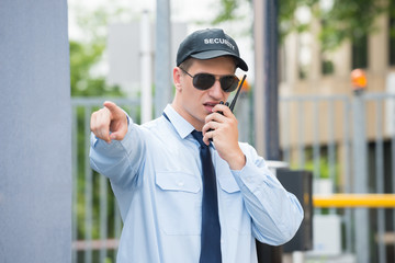 Male Security Guard Using Walkie Talkie