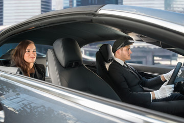 Young Woman Riding In A Car With Chauffeur