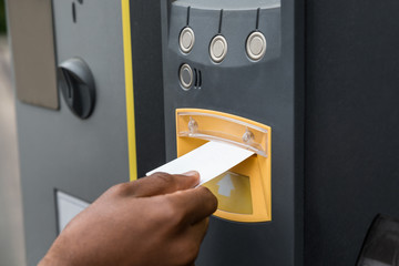 Person's Hand Inserting Ticket Into Parking Machine