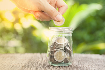 women hand putting money coin in jar. concept saving money  grow