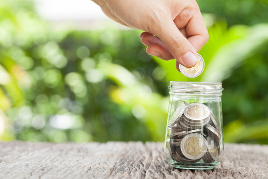 women hand putting money coin in jar. concept saving money  grow