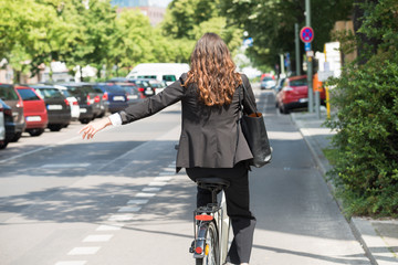 Young Businesswoman Showing Turn On Bicycle