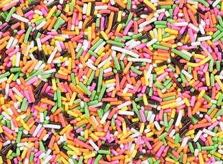 Fototapeta na wymiar Colorful candy sprinkles background. Top view