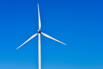 Fototapeta premium Windmills for electric power production on blue sky
