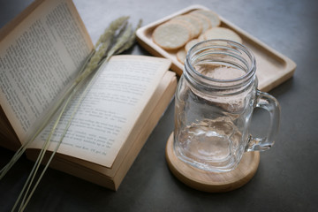 Empty glass cup and book on the table