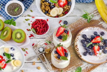 Yogurt, muesli and fruits for healthy diet breakfast. Flat lay