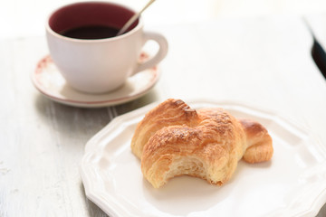 Bited croissant and coffee cup