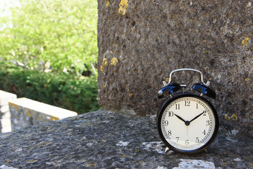 Alarm clock on the stone wall