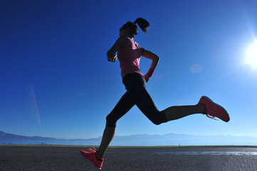 Fototapeta na wymiar young fitness woman runner running on sunrise seaside trail