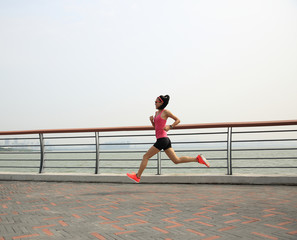 young fitness woman runner running at seaside