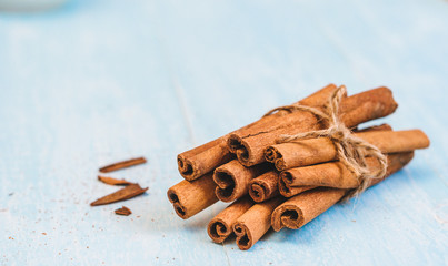 Ground cinnamon, sticks, tied with jute rope on old wooden background, selective focus, space for text,