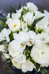 Bouquet of white flowers: ranunculus, freesia and orchid.
