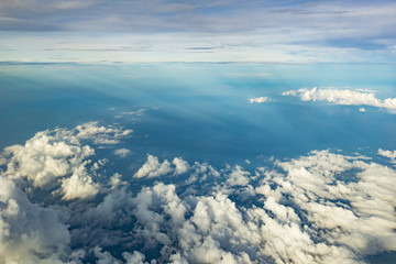 Clouds over blue water from airplane