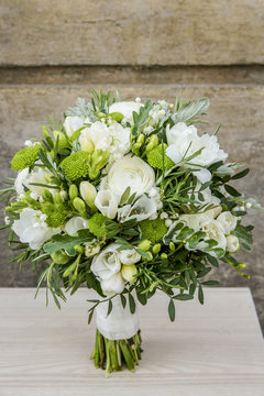Wedding bouquet with white flowers and green leaves.