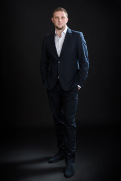 Portrait of handsome stylish man in elegant suit on black background