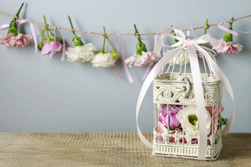 Vintage bird cage with flowers inside