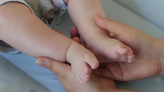 Slow motion shot of a newborn baby feet cupped into mothers hands