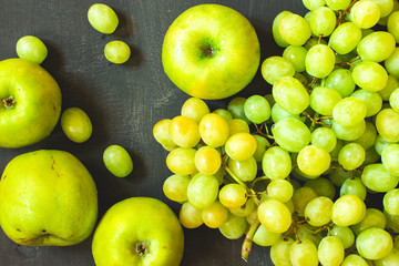 Grapes and apples on a black wooden background, horizontal, soft focus