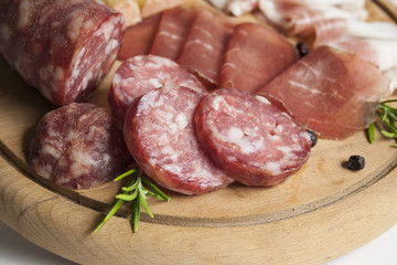 Primo piano tagliere con affettati tradizionali italiani: salame, bresaola, lardo e formaggio