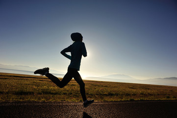  young fitness woman runner running on sunrise seaside trail