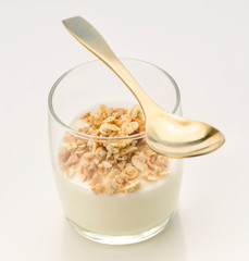 Vertical making yogurt and organic cereals with golden spoon