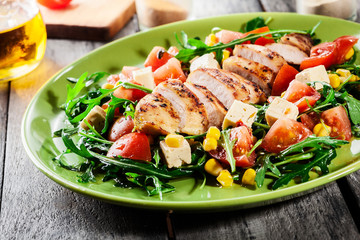 Fresh salad with chicken breast, arugula and tomato
