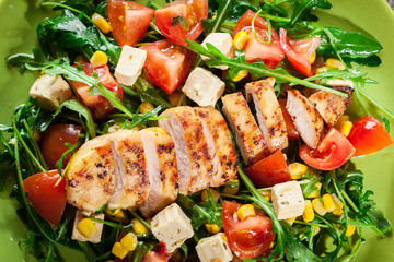 Fresh salad with chicken breast, arugula and tomato