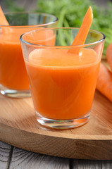 Fresh carrot juice on wooden background, selective focus