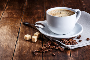 white cup of coffee with roasted beans