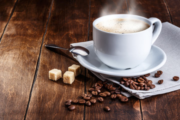 white cup of coffee with roasted beans