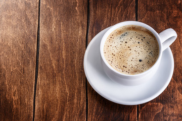 white mug of coffee on a wooden background