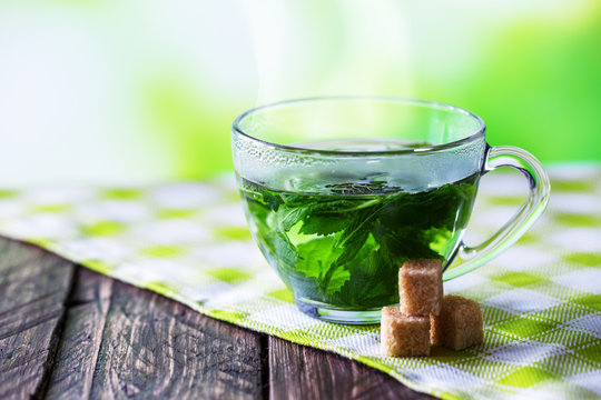 green tea, refined brown sugar on a wooden background