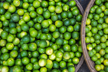 Lime fruits on the big plate on farmers market, close up