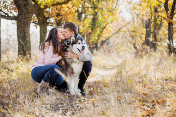 Fototapeta premium Man and woman hugging a dog