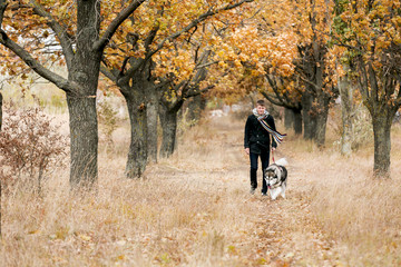 Fototapeta premium man walking with a dog Husky
