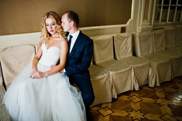 Fototapeta na wymiar Beautiful blonde bride with groom at grand palace