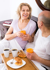 Obraz na płótnie Canvas Couple having breakfast in bed