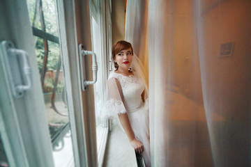 Fototapeta na wymiar The charming bride looks at window