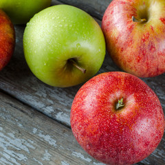 Red and green apples with drops of dew.