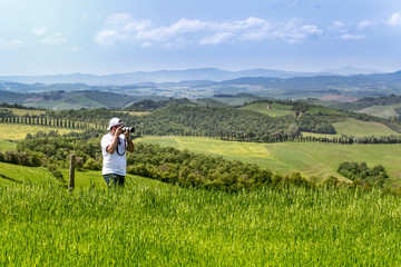 Tourist photographing tuscan landscape