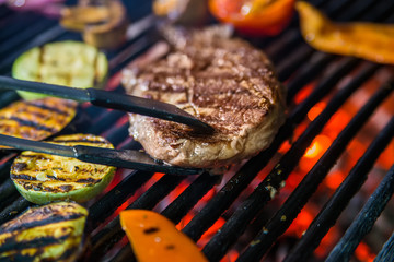 Beef steaks on the grill with flames