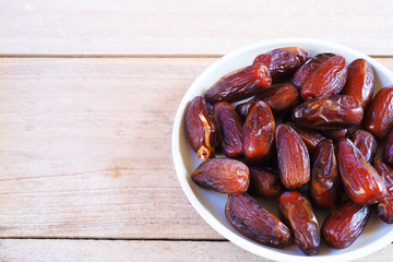 Top view of pile of dried date fruit on a wooden table.