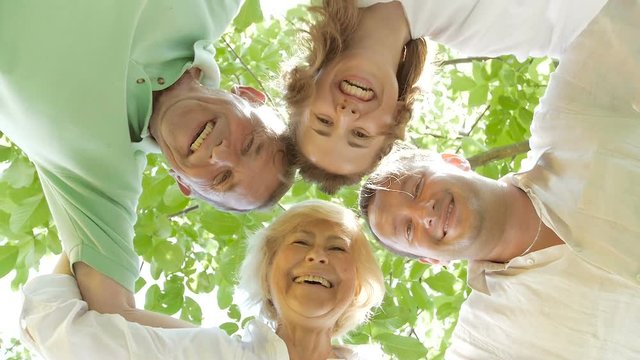 Family bent over the camera and smiling.