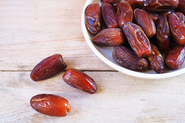 Top view of pile of dried date fruit on a wooden table.