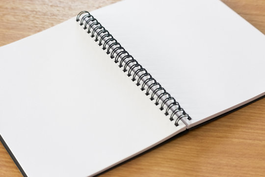 Blank notebook on the wooden desk background
