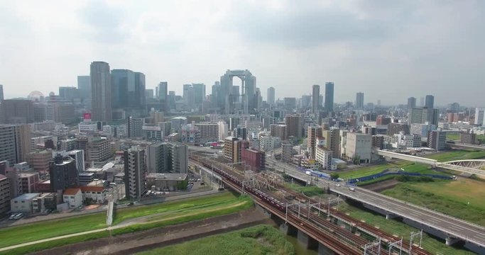 Decending aerial view of Osaka city train transport into CBD 
